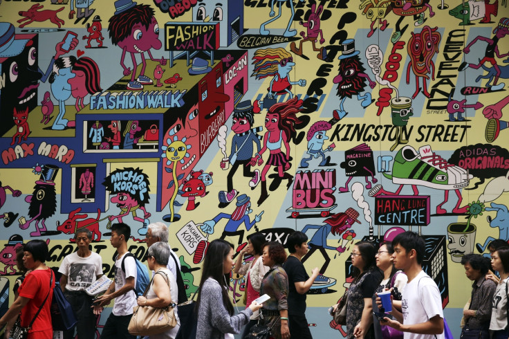 Commuters and shoppers pass by a colourful wall at the Causeway Bay shopping district in Hong Kong