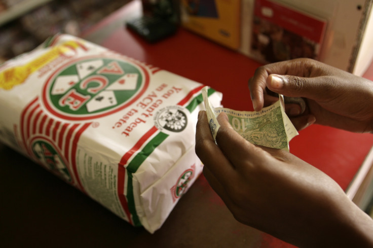customer prepares to pay for a small bag of maize meal at a shop in Soweto south west of Johannesburg