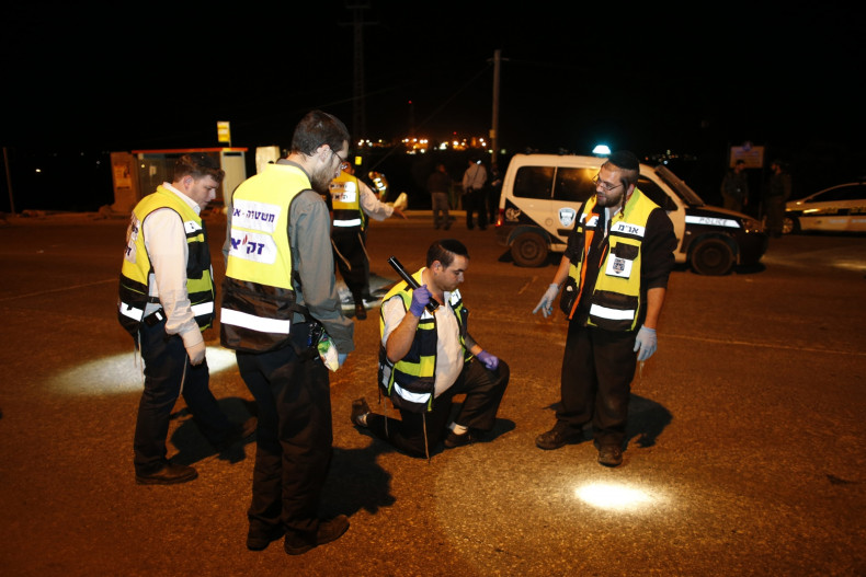 Members of the Israeli Zaka emergency response team survey the scene of a stabbing attack near the West Bank