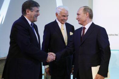 Russian President Vladimir Putin (R) shakes hands with ex-Deutsche Bank Chief Executive Officer Josef Ackermann (L) as the head of Knauf Group Nikolaus Wilhelm Knauf in 2010