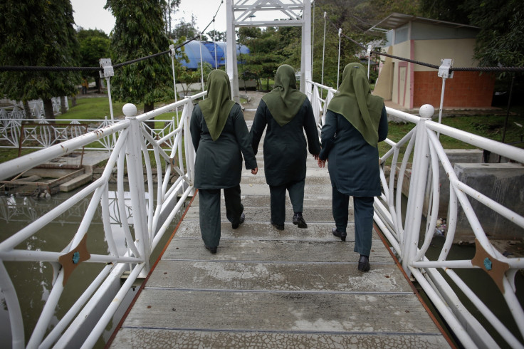 Female members of the sharia police force known as Wilayatul Hisbah (WH) enter a public park as they search for those violating the law during their patrol in Banda Aceh December 6, 2012