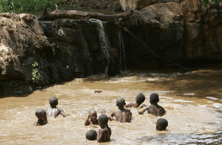 Children enjoy their school holidays by cooling off in muddy water in Tshaulu village in Limpopo province, South Africa, December 28, 2006. REUTERS/Siphiwe Sibeko (SOUTH AFRICA)