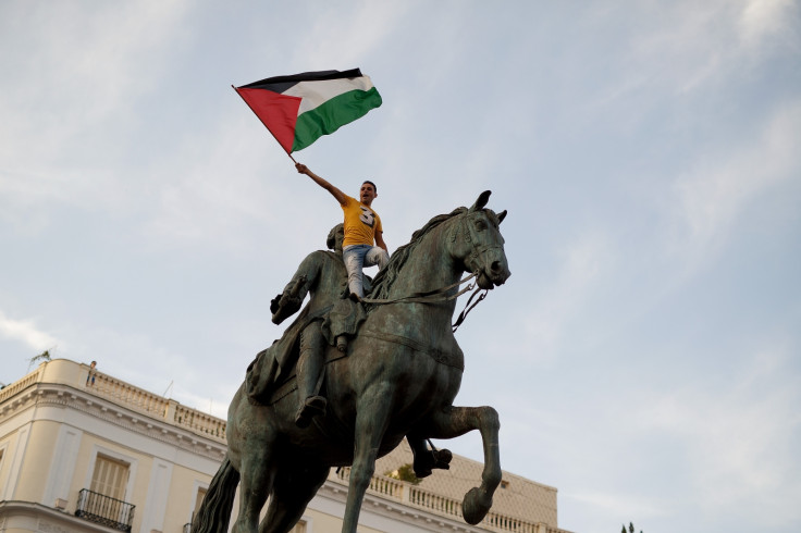 A pro-Palestine protester in Spain climbs a statue of Carlos II in Madrid in July. (Getty)