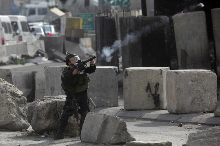 A member of the Israeli security forces clashes with Palestinian protesters