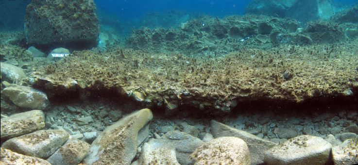 The remains of stone walls, with the 16 terracotta pots inset on the seabed