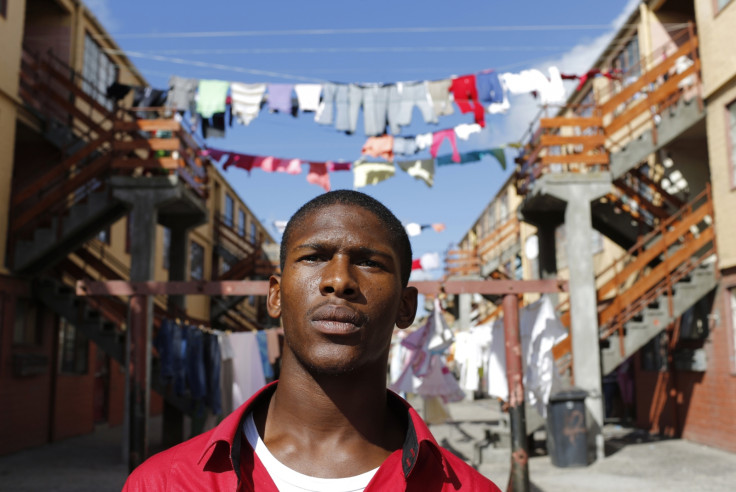 Youth worker Nathaniel Groep, 19, stands in front of flats outside his home in Mannenberg, a gang-ravaged township, in Cape Town April 18, 2014