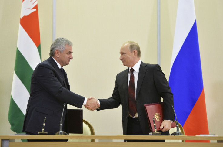 Russian President Vladimir Putin (R) shakes hands with Abkhazia's President Raul Khadzhimba during a signing ceremony at the Bocharov Ruchei state residence in Sochi