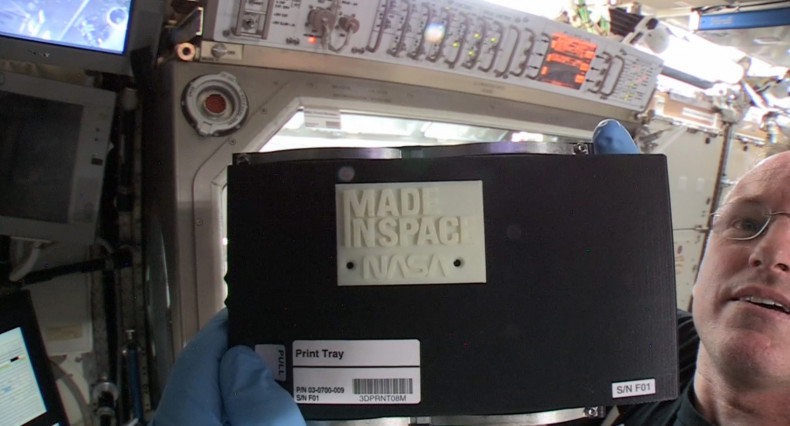 Nasa astronaut Barry "Butch" Wilmore holds up the first ever 3D-printed item in space