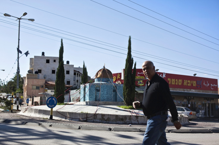 An Israeli Arab man walks past a replica of the Dome of the Rock mosque, in the Arab town of Kafr Qassem