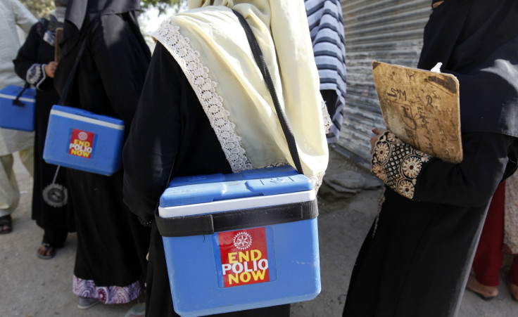 Polio vaccinators carry boxes of polio vaccine drops as they head to the areas they have been appointed to administer the vaccine, in Karachi October 21, 2014.