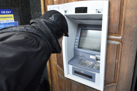 A man stands in front an ATM machine which is out of order, on November 26, 2014 in the eastern Ukrainian city of Donetsk