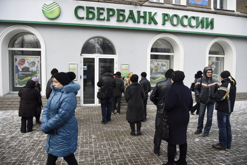 People wait in front of a closed bank on November 26, 2014 in the eastern Ukrainian city of Donetsk. No automated teller machines were working and most shops didn't accept payment by credit cards in Donetsk after Kiev asked for the suspension of banking