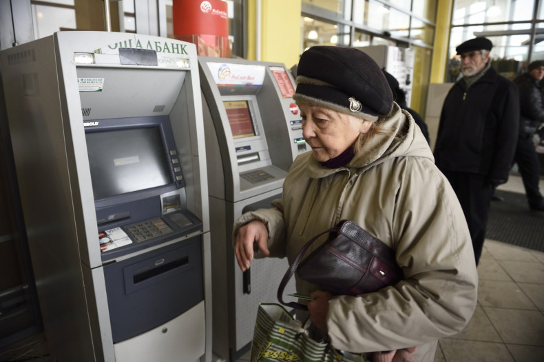 A woman walks in front of an ATM machine after she tried to get cash on November 26, 2014 in the eastern Ukrainian city of Donetsk.