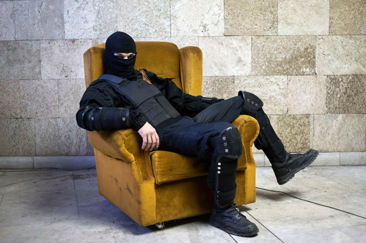 April 25, 2014: A masked pro-Russian protester sits on a chair as he poses for a picture inside a regional government building in Donetsk, eastern Ukraine