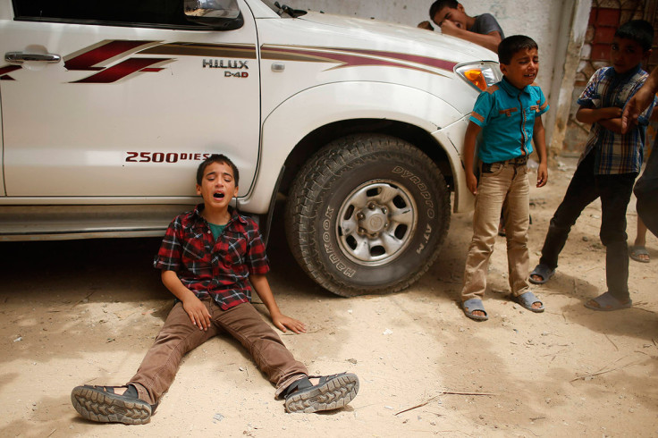 July 13, 2014: The son of one of the members of Tayseer Al-Batsh's family, who hospital officials said were killed in an Israeli air strike, mourns during their funeral in Gaza City