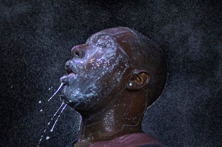 August 20, 2014: A man is doused with milk and sprayed with mist after being hit with an eye irritant by security forces in Ferguson, Missouri
