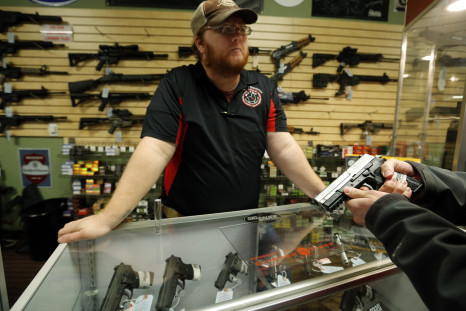 Metro Shooting Supplies' employee Chris Cox speaks to a customer about the purchase of a 9mm handgun in Bridgeton, Missouri