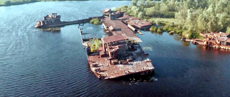 Rusting abandoned ships, half-sunk into the water at the port in Prypiat