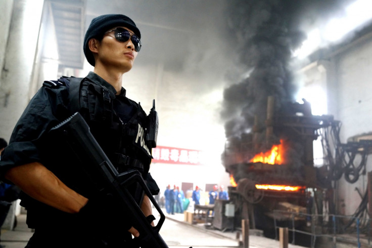 Chinese police stand guard as a drugs factory in Guizhou province is destroyed.