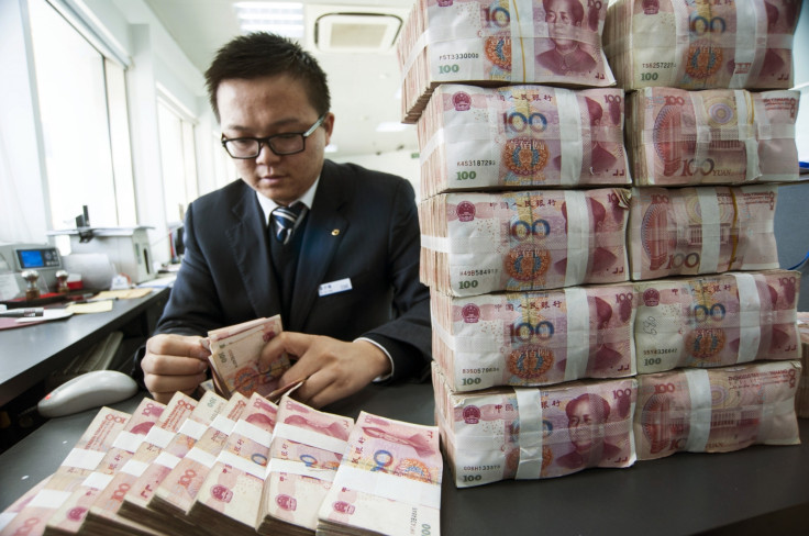 A clerk counts Chinese 100 yuan banknotes at a branch of China Construction Bank