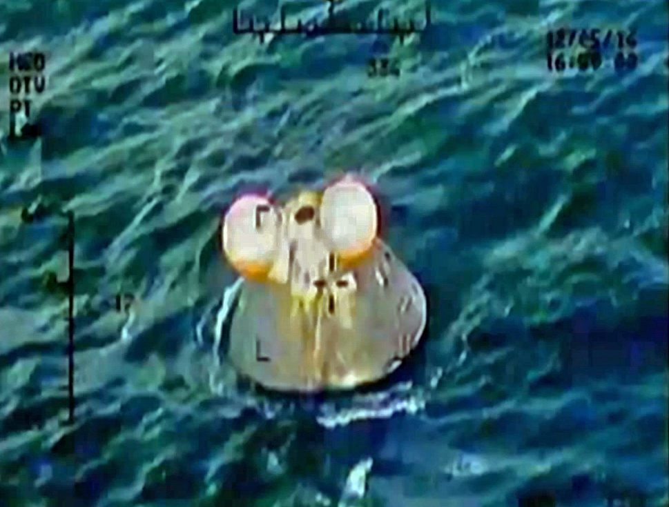 Footage from Nasas Ikhana unmanned aerial vehicle, showing the Orion crew module safely landed in the water with two of its three main parachutes intact