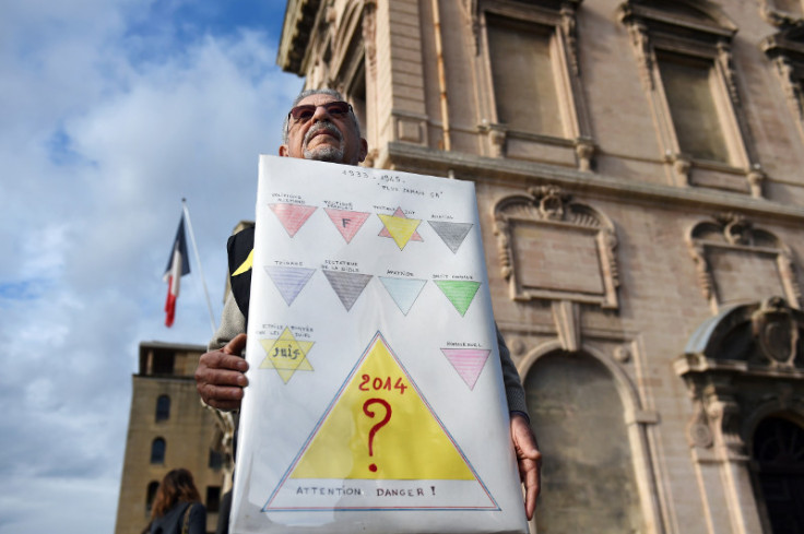 A protester holds a sign comparing the Homeless identity cards introduced in Marseille with the yellow Star of David Jews were forced to wear in Nazi Germany. (Anne-Christine Poujoulat/AFP)