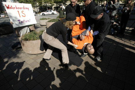 Demonstrator Maboud Ebrahimzadeh is lowered onto the board during a simulation of waterboarding outside the Justice Departement in Washington