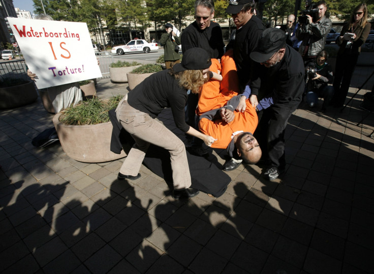 Demonstrator Maboud Ebrahimzadeh is lowered onto the board during a simulation of waterboarding outside the Justice Departement in Washington