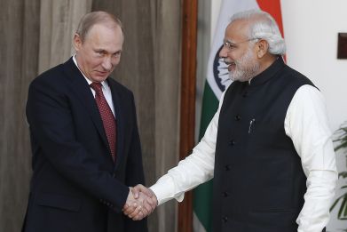 Russian President Vladimir Putin (L) shakes hands with India's Prime Minister Narendra Modi during a photo opportunity ahead of their meeting at Hyderabad House in New Delhi
