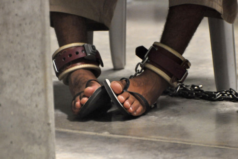 In this photo, reviewed by a U.S. Department of Defense official, a Guantanamo detainee's feet are shackled to the floor as he attends a