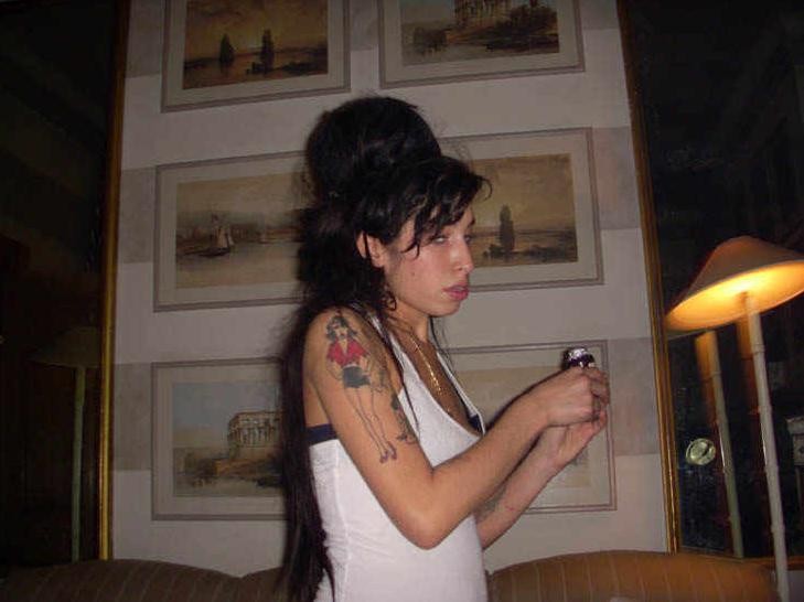 Amy Winehouse holding a makeshift crack pipe