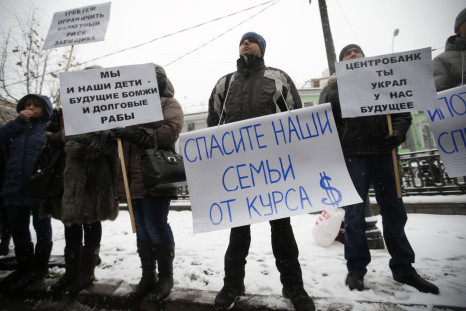 Protesters hold placards during a picket in central Moscow, December 12, 2014. According to local media, the people, who took mortgages in foreign currencies, now face larger risks due to the weakening of the rouble. The placards read, "We and our childr