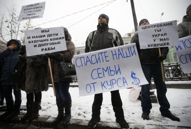 Protesters hold placards during a picket in central Moscow, December 12, 2014. According to local media, the people, who took mortgages in foreign currencies, now face larger risks due to the weakening of the rouble. The placards read, "We and our childr