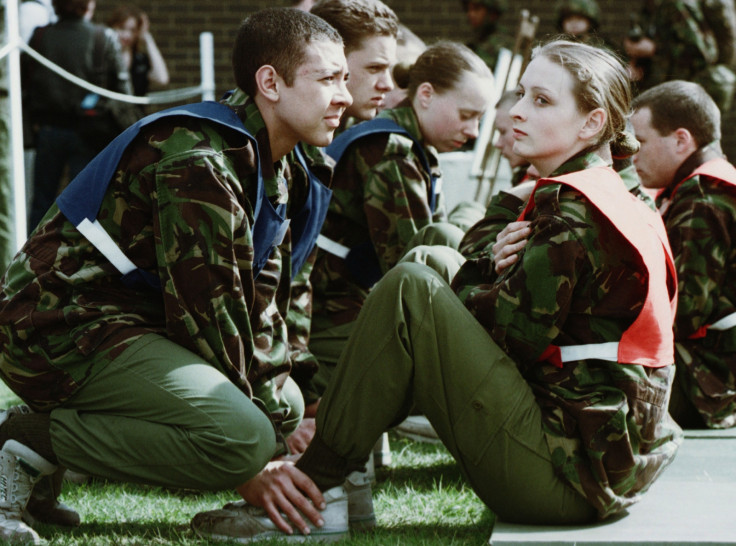 A female recruit does situps while a male recruit holds her ankles during the new equal opportunities physical tests for the British Army in Pirbright