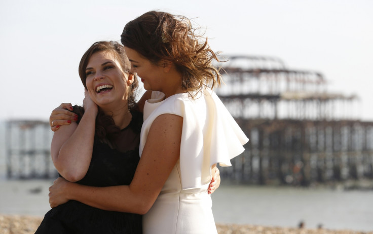 Lesbian couple Sarah Keith (R) and Emma Powell pose for photographs after their same-sex wedding at the Claremont Hotel in Brighton, southern England