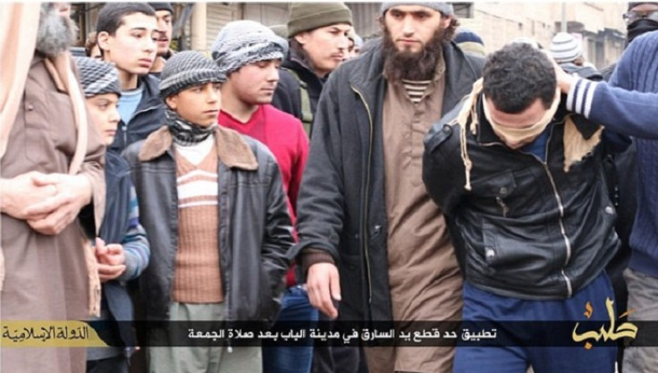 Blindfolded man is shown being led to the centre of the street before his hand is cut off