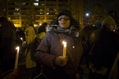 A woman holds a candle as demonstrators gather in Central Park in Harlem, New York City, for a candlelight vigil and march for justice December 21, 2014.