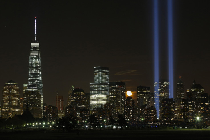 The moon rises behind the skyline of lower Manhattan