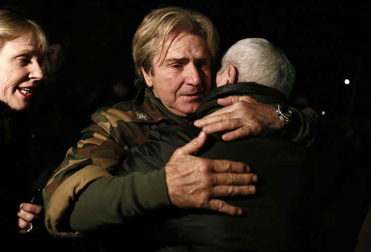 Andreas Tolaros, who was rescued from the Norman Atlantic ferry, hugs a friend after arriving at the Elefsina air-base near Athens