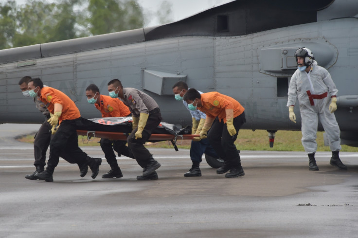 Members of an Indonesian search and rescue team collect a bag containing a victims body of AirAsia flight 8501, from a US navy helicopter Seahawk. (ADEK BERRY/AFP/Getty Images)