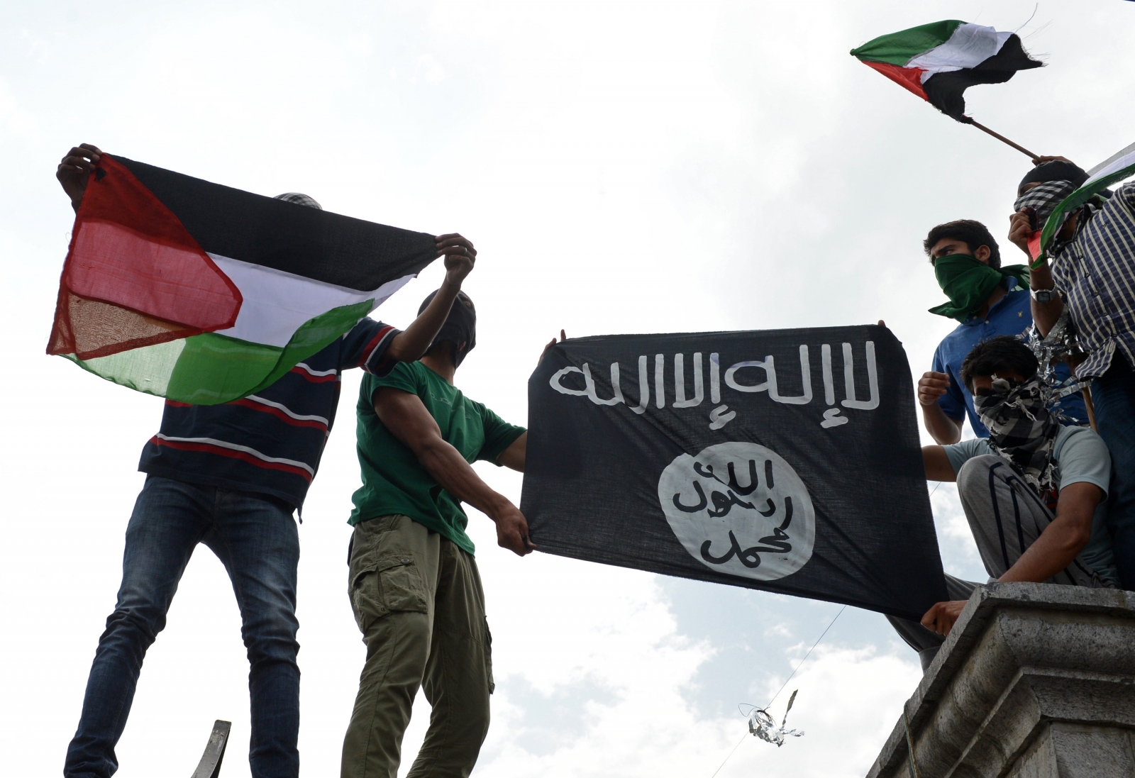 Demonstrators in Kashmir hold aloft Isis and Palestine flags in a protest against Israeli bombings of the West Bank. (Getty)