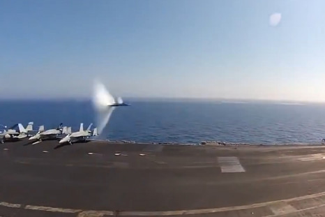 US navy jet breaks speed of sound flying past aircraft carrier
