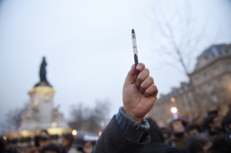A man raises a pen during a rally in support of the victims of today's terrorist attack on French satyrical newspaper Charlie Hebdo