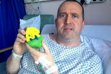 John Cousins holds up a 3D-printed model of his kidney from hospital