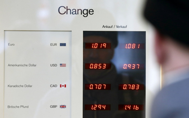 A man looks at a board showing currency exchange rates in Bern January 15, 2015. The Swiss National Bank shocked financial markets on Thursday by scrapping a three-year-old cap on the franc, sending the safe-haven currency soaring against the euro and sto