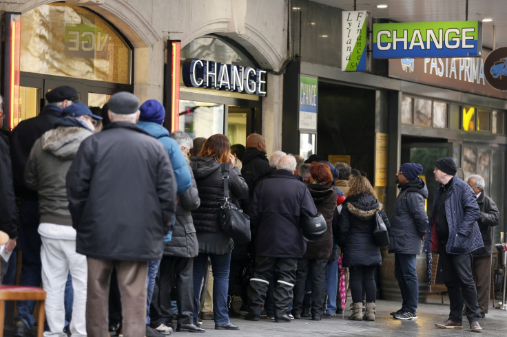 People queue outside a currency exchange office in Geneva, January 16, 2015. Swiss stocks sank on Friday, extending the sell-off sparked by the Swiss National Bank's surprise decision to remove a ceiling on the Swiss franc that sent the currency soaring.