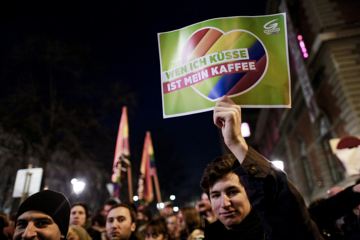 A protestor holds a banner reading 'who I kiss is my cup of coffee' during a protest themed 'Kuessen im Prueckel' (kissing in Prueckel) in Vienna