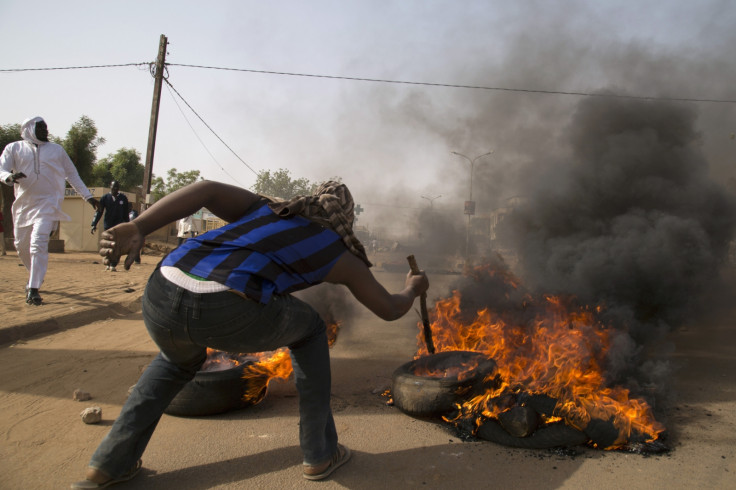 A man burns a tire during a protest against Niger President Mahamadou Issoufou's attendance last week at a Paris rally in support of French satirical weekly Charlie Hebdo