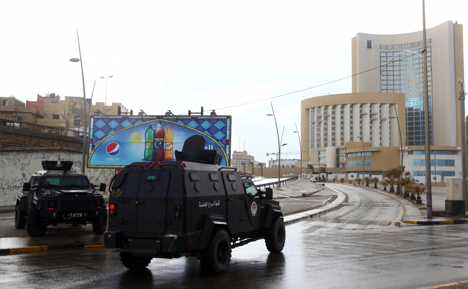 Libyan security forces and emergency services surround Tripoli's central Corinthia Hotel (R) on January 27, 2015 in the Libyan capital