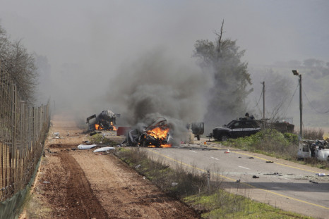 Burning vehicles are seen near the village of Ghajar on Israel's border with Lebanon